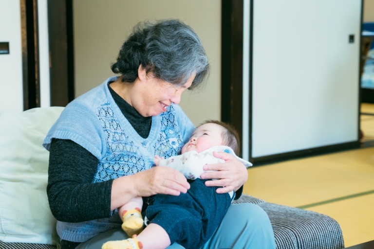 高齢者が赤ちゃんと交流する様子。多世代交流プログラムの場面
